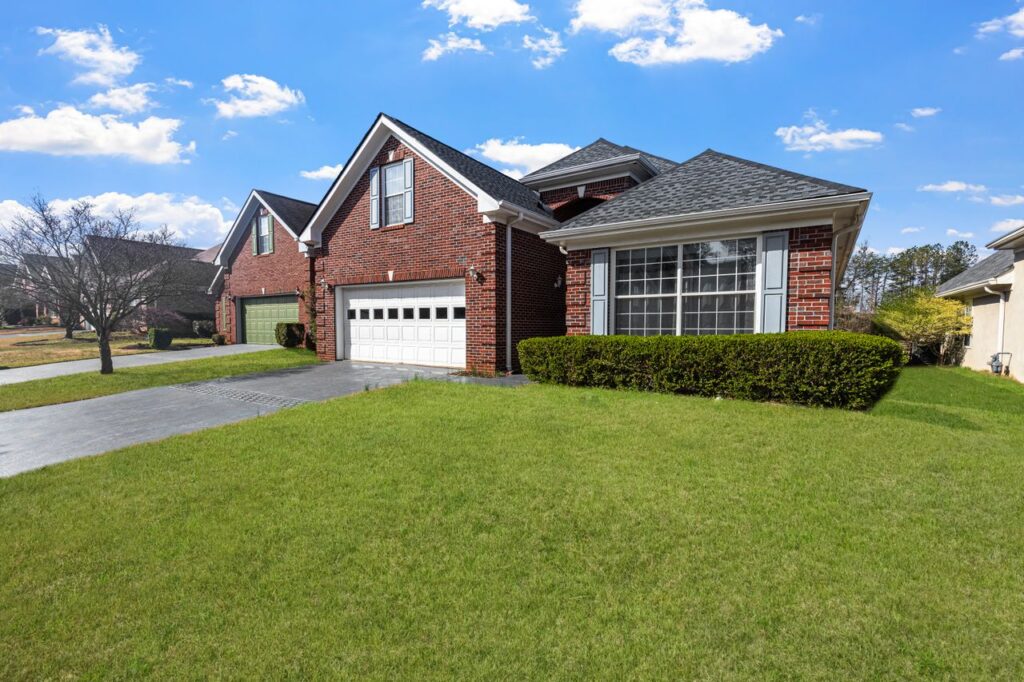 Two-story brick home with white garage door and manicured lawn in a Kernersville, NC neighborhood